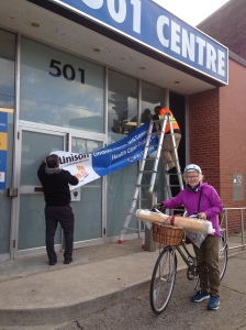 picture of health centre exterior with Janet in foreground with her bike